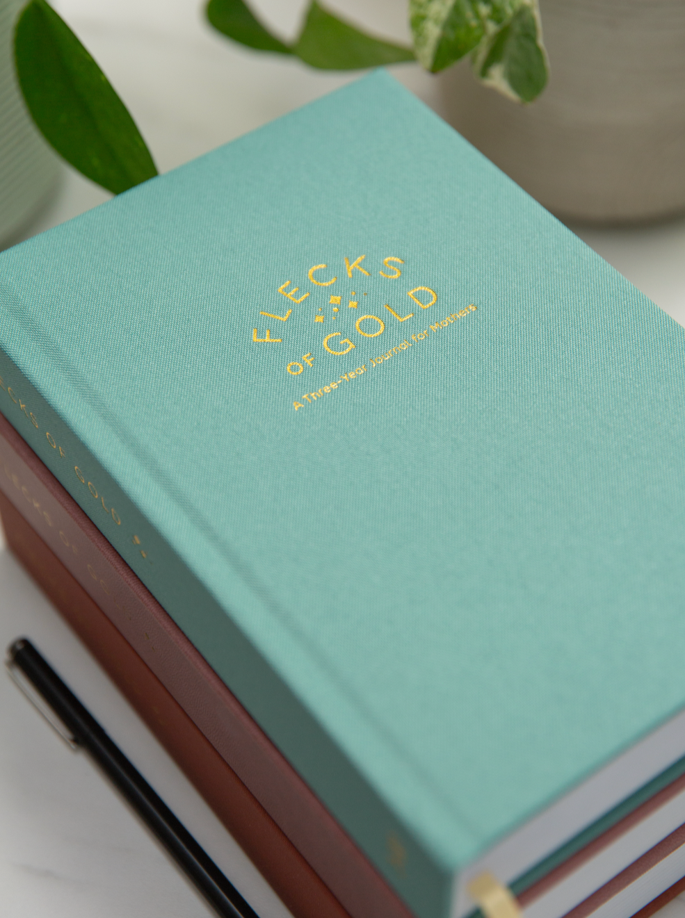 Teal Linen Flecks of Gold Journal with gold embossing. A Three-Year Journal For Mothers. Helping you find the joy in Motherhood. A journal for moms who want to see the good in every day. Helping overwhelmed, busy moms. Created by Rachel Nielson of 3 in 30 Podcast.  Motherhood Journal.  Three-year journal. Gratitude Journal.