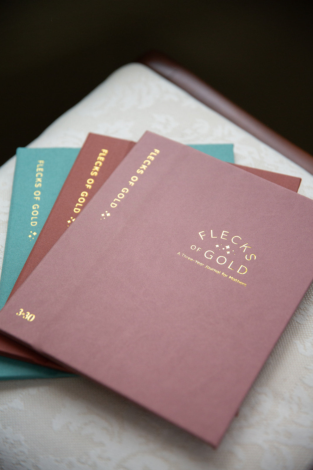Flecks of Gold Journals with gold embossing. A Three-Year Journal For Mothers. Helping you find the joy in Motherhood. A journal for moms who want to see the good in every day. Helping overwhelmed, busy moms. Created by Rachel Nielson of 3 in 30 Podcast. Motherhood Journal. Gratitude Journal.