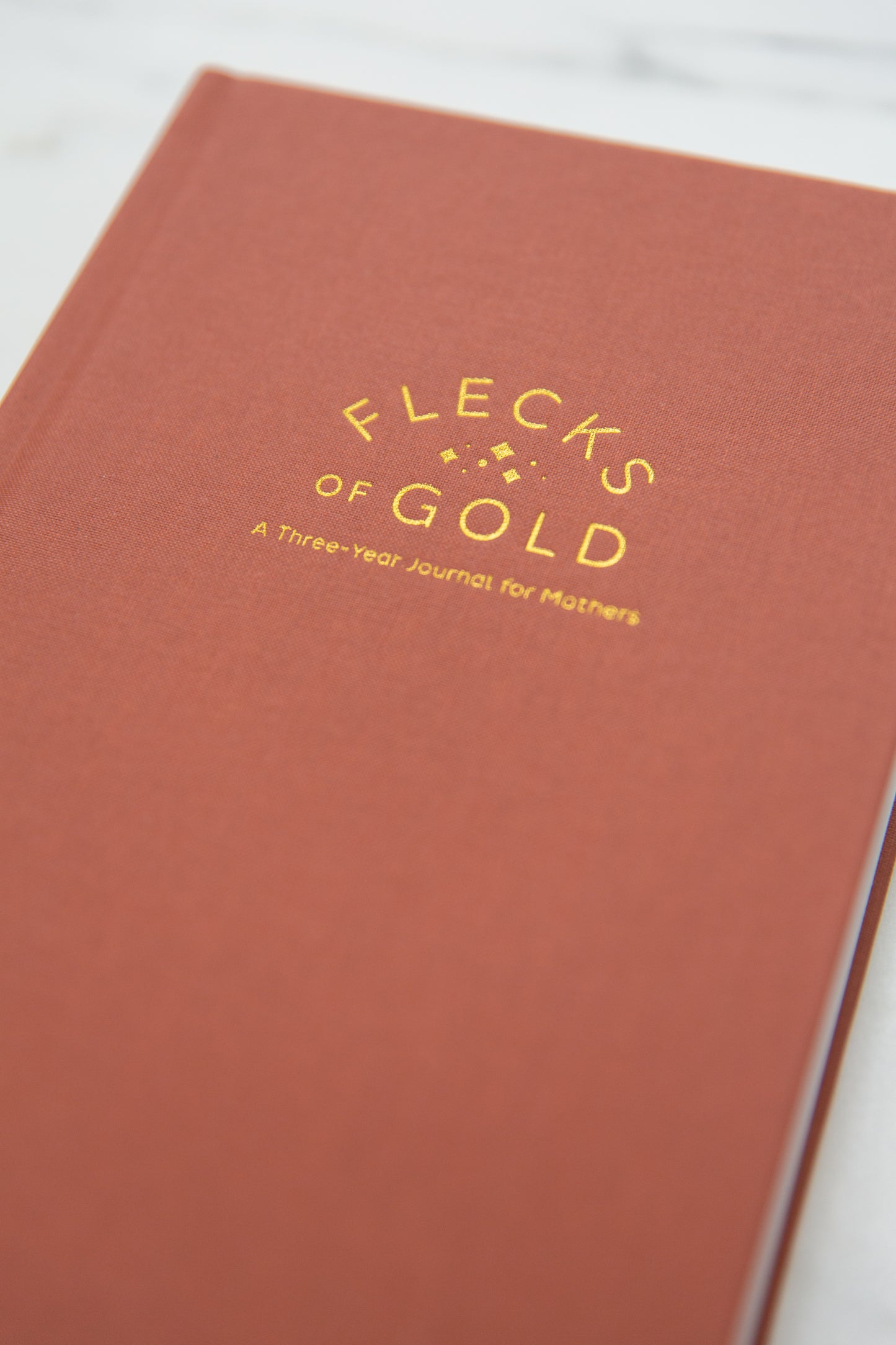Terracotta Linen Flecks of Gold Journal with gold embossing. A Three-Year Journal For Mothers. Helping you find the joy in Motherhood. A journal for moms who want to see the good in every day. Helping overwhelmed, busy moms. Created by Rachel Nielson of 3 in 30 Podcast.