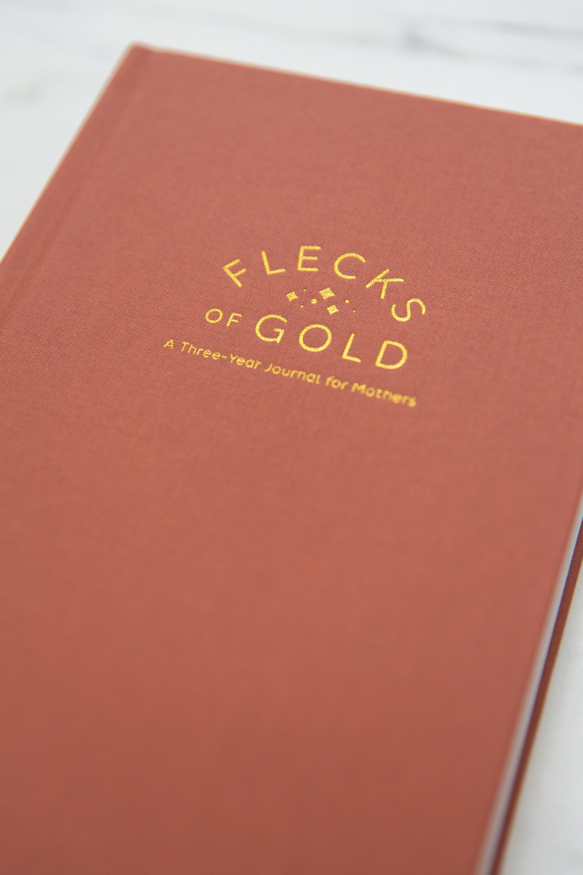 Terracotta Linen Flecks of Gold Journal with gold embossing. A Three-Year Journal For Mothers. Helping you find the joy in Motherhood. A journal for moms who want to see the good in every day. Helping overwhelmed, busy moms. Created by Rachel Nielson of 3 in 30 Podcast.