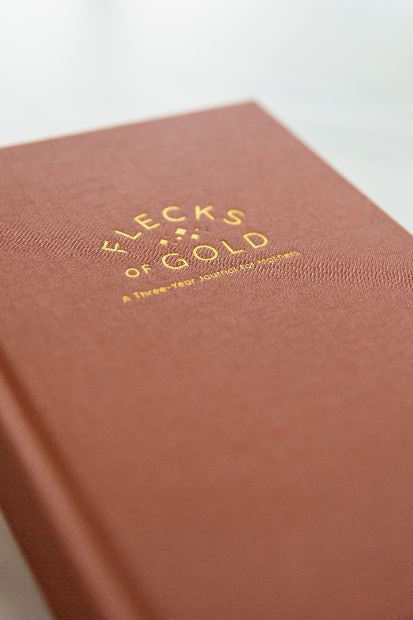 Terracotta Linen Flecks of Gold Journal with gold embossing. A Three-Year Journal For Mothers. Helping you find the joy in Motherhood. A journal for moms who want to see the good in every day. Helping overwhelmed, busy moms. Created by Rachel Nielson of 3 in 30 Podcast.