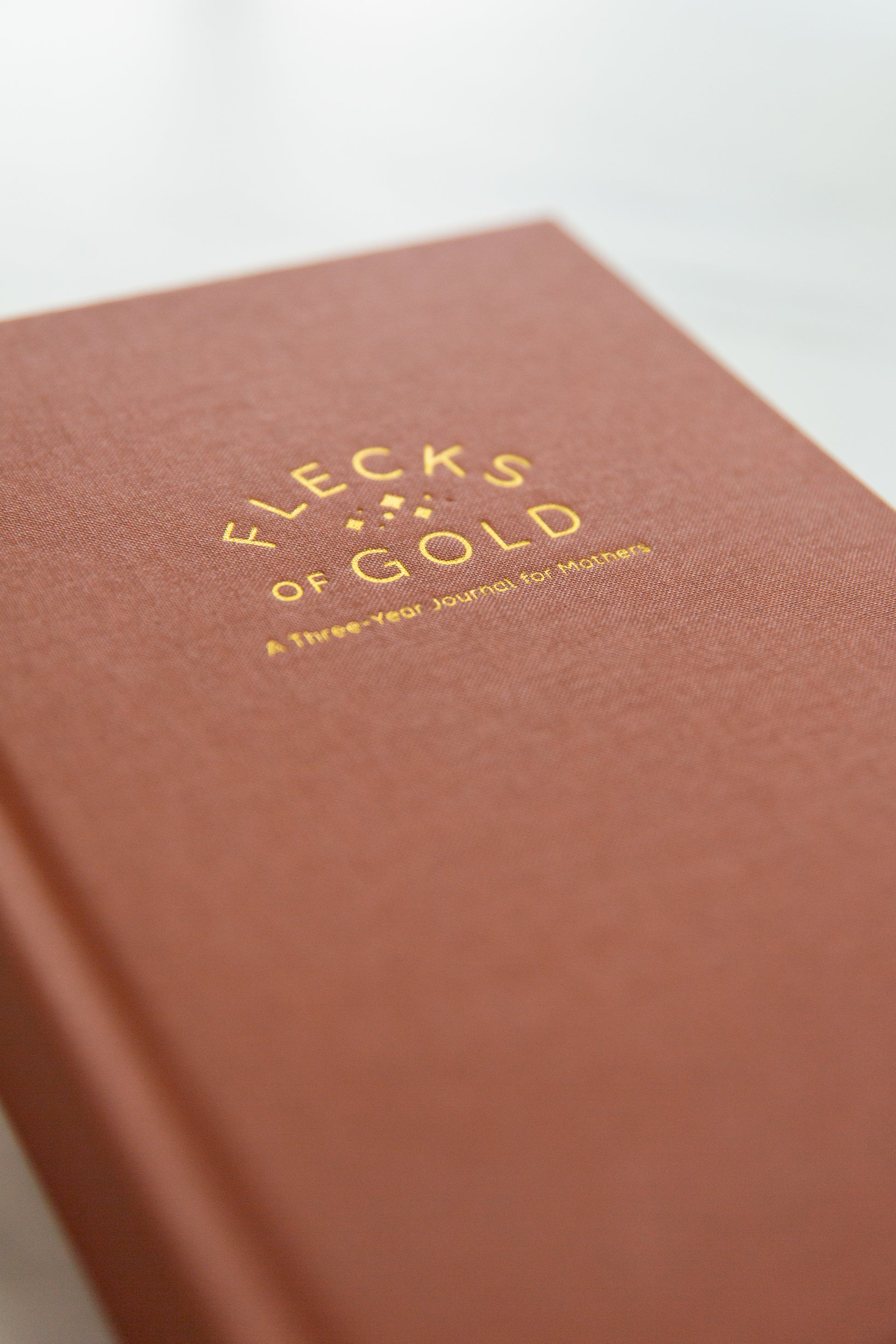 Terracotta Linen Flecks of Gold Journal with gold embossing. A Three-Year Journal For Mothers. Helping you find the joy in Motherhood. A journal for moms who want to see the good in every day. Helping overwhelmed, busy moms. Created by Rachel Nielson of 3 in 30 Podcast.
