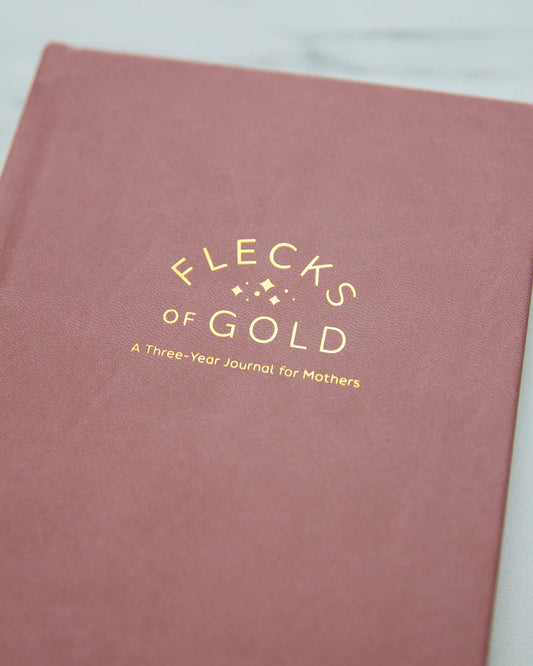 Close-up of the rose vegan leather cover with gold-foil Flecks of Gold title