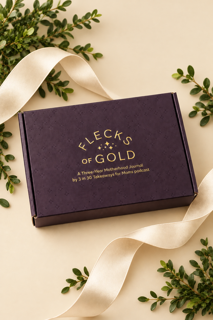Flecks of Gold journal gift box in deep plum with gold-foil lettering, surrounded by cream satin ribbon and greenery